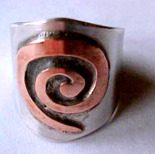 image of silver ring with copper koru decoration