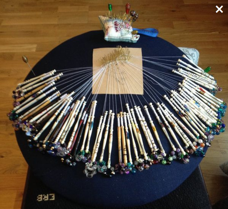 image of Bobbin lace pillow with bobbins